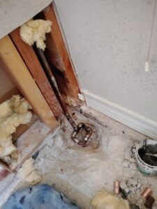 Damaged cold water line exposed at a concrete grade beam during a slab leak repair in Arlington, TX