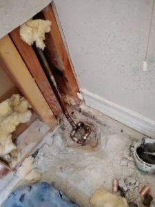 Damaged cold water line exposed at a concrete grade beam during a slab leak repair in Arlington, TX