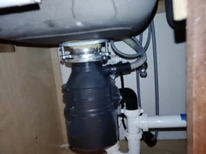 Garbage disposal with repaired dishwasher drain connection and new drain piping under a kitchen sink in Burleson, TX