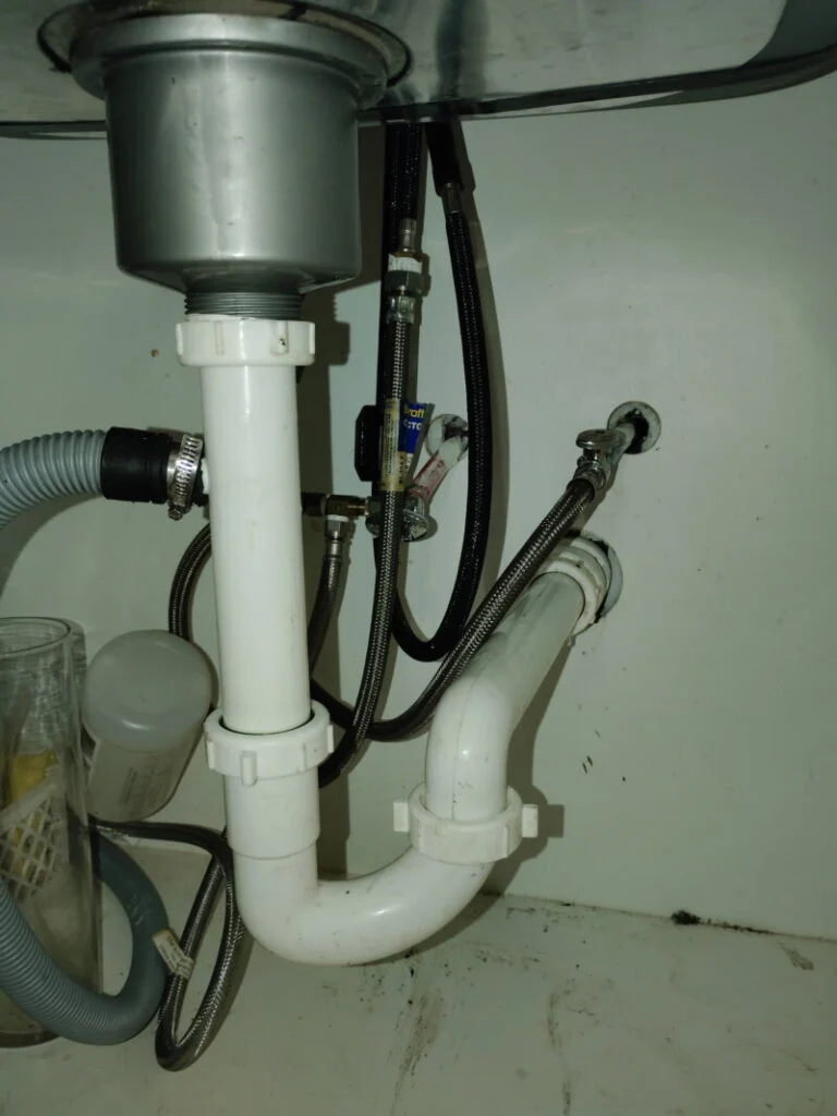 Repaired kitchen sink drain and P-trap under a sink in a Burleson, TX home