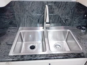 New single-handle pull-down kitchen faucet on a stainless double-bowl sink in Burleson, TX